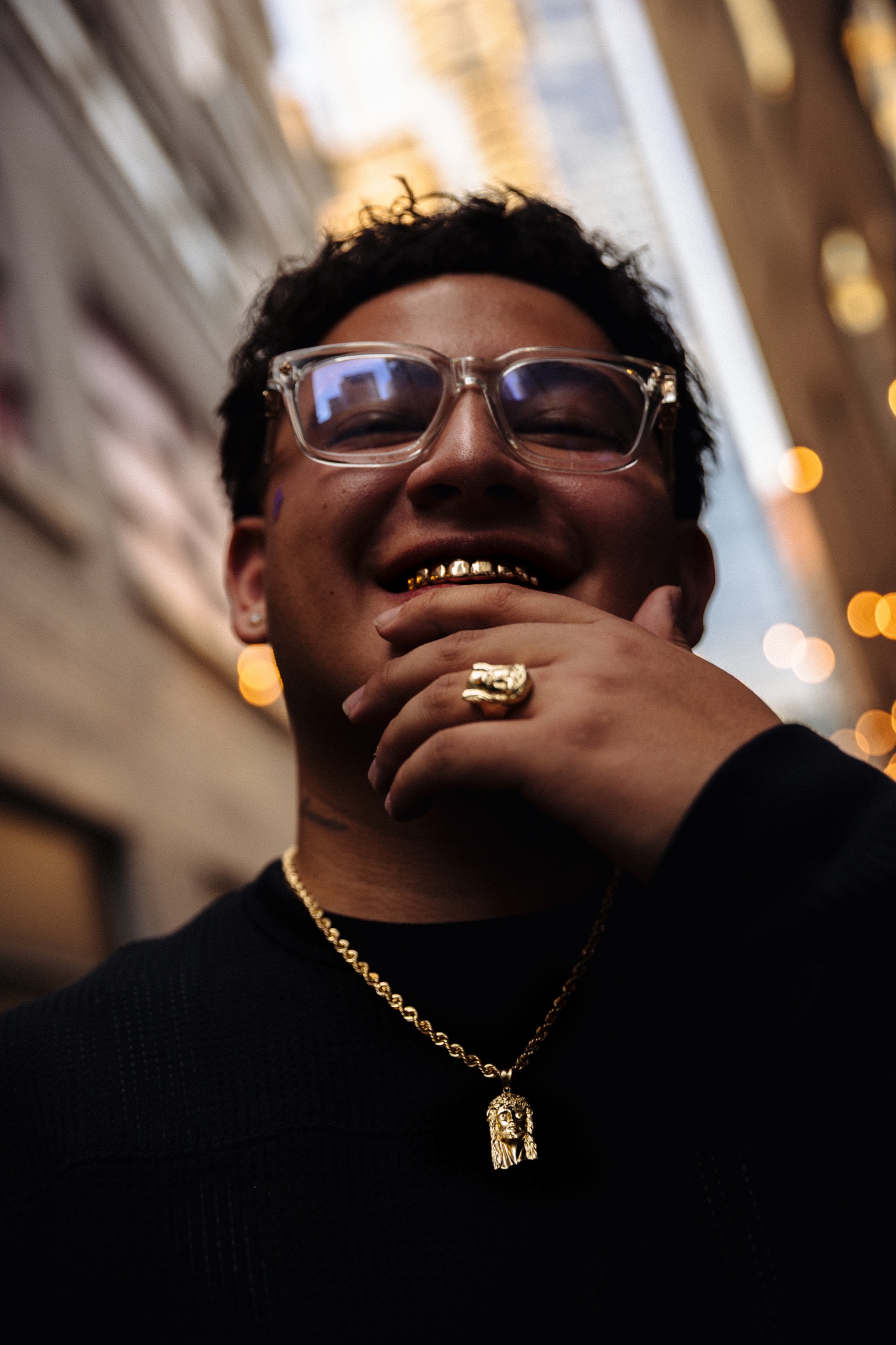 Close-up portrait of Karri wearing glasses and gold jewelry